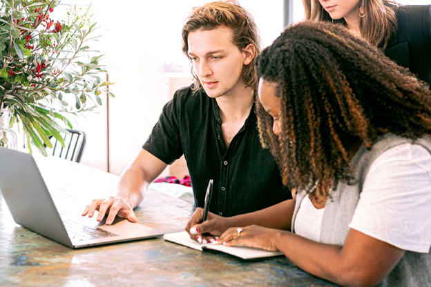 Several people taking notes and working on a laptop